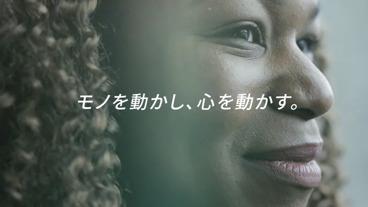 A woman's face in close-up with the line 「モノを動かし、心を動かす。」