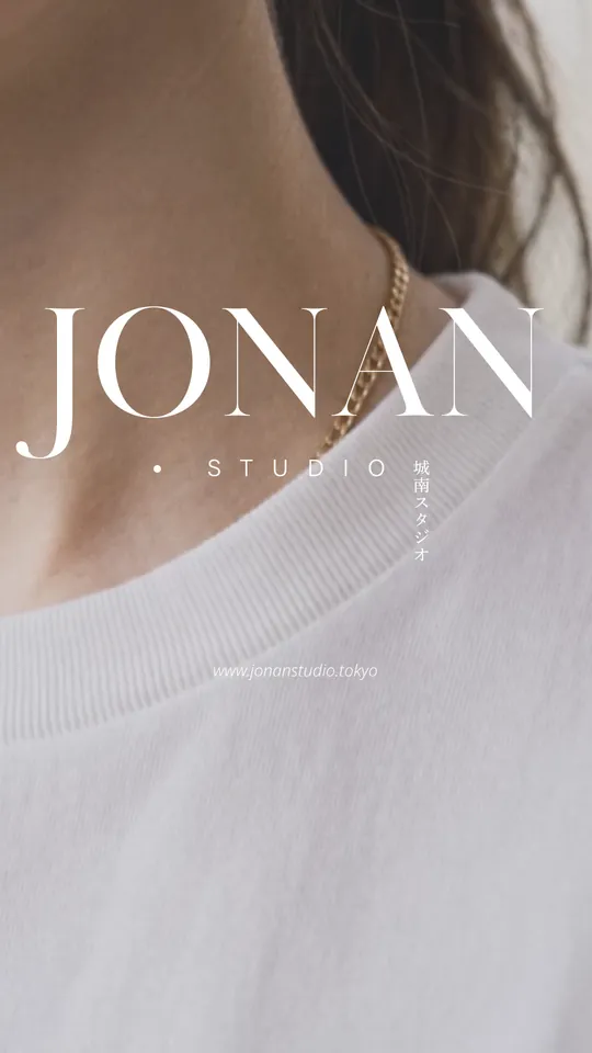 Close-up of a white tee's collar and a gold chain — “JONAN STUDIO”