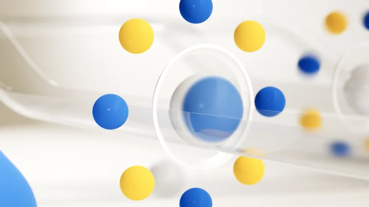 A blue sphere inside a glass ring, ringed by blue and yellow balls