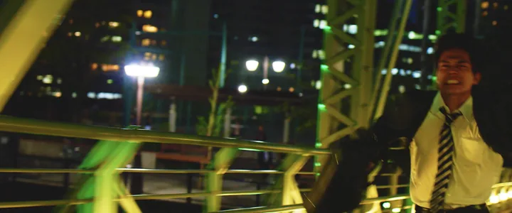 A man laughing on a lit rooftop at night