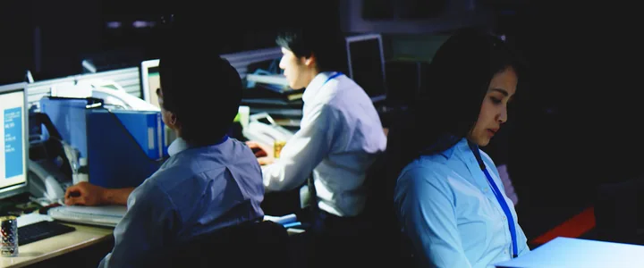 Colleagues working late in a dark office