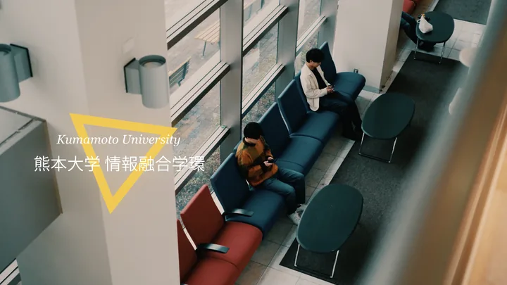 Students in the atrium lobby from above, with the 熊本大学 情報融合学環 logo