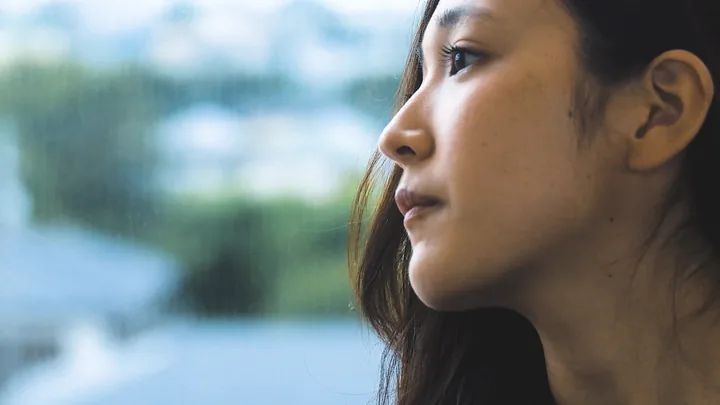 A young woman in profile, looking out