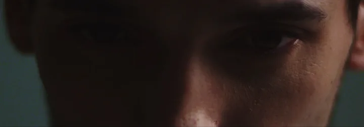 A man's face in shadow, close-up