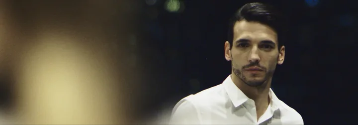 A man in a white shirt against city bokeh