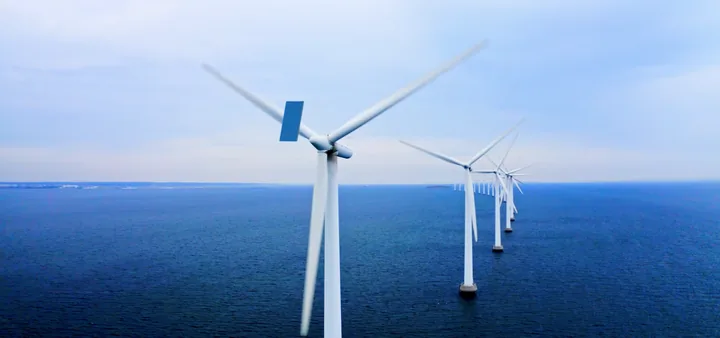 Offshore wind turbines at dusk with the SMFL mark
