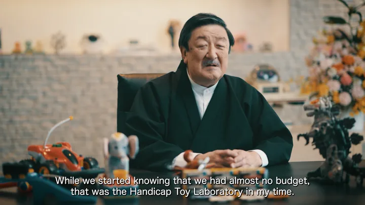 Kantaro Tomiyama speaking among toys — about the Handicap Toy Laboratory