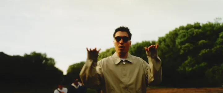 The crew performing in a park, one raising his hands