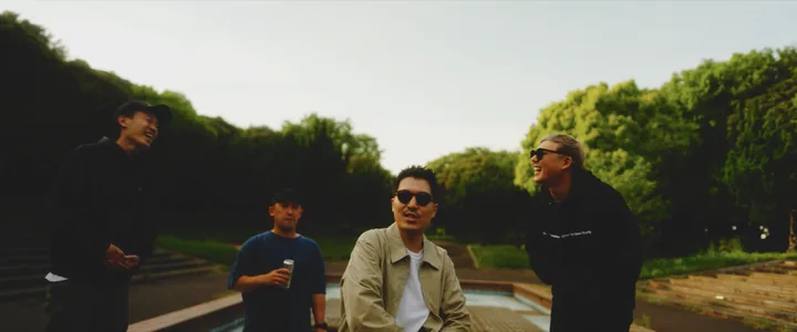 The crew gathered around the lead in a beige jacket