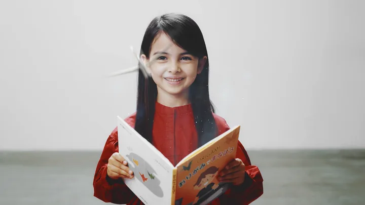 A girl in red reading an origami picture book