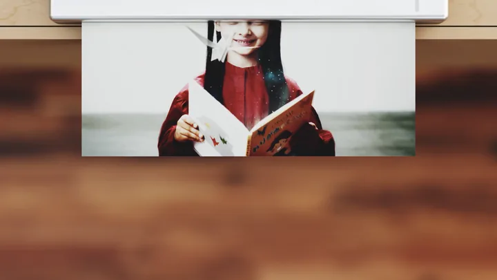 A printer printing a photo of the girl with her book
