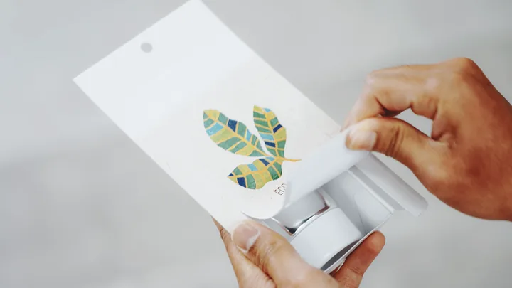 Hands opening a printed paper package