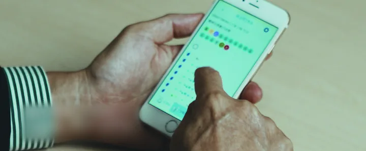 Hands working a colour-coded app on a phone