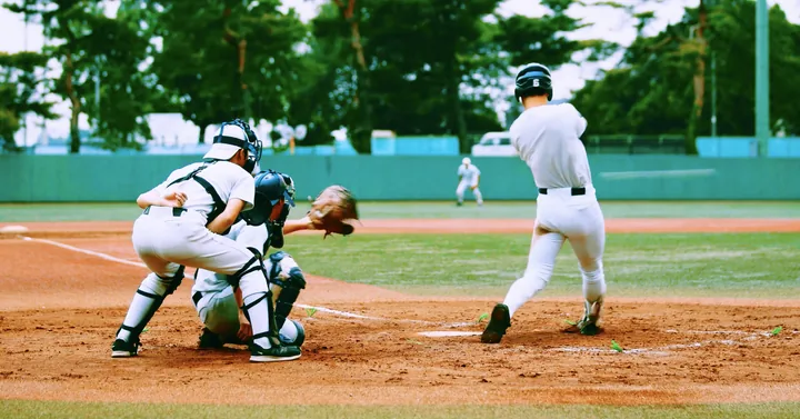 A batter swinging at the plate in a campus baseball game